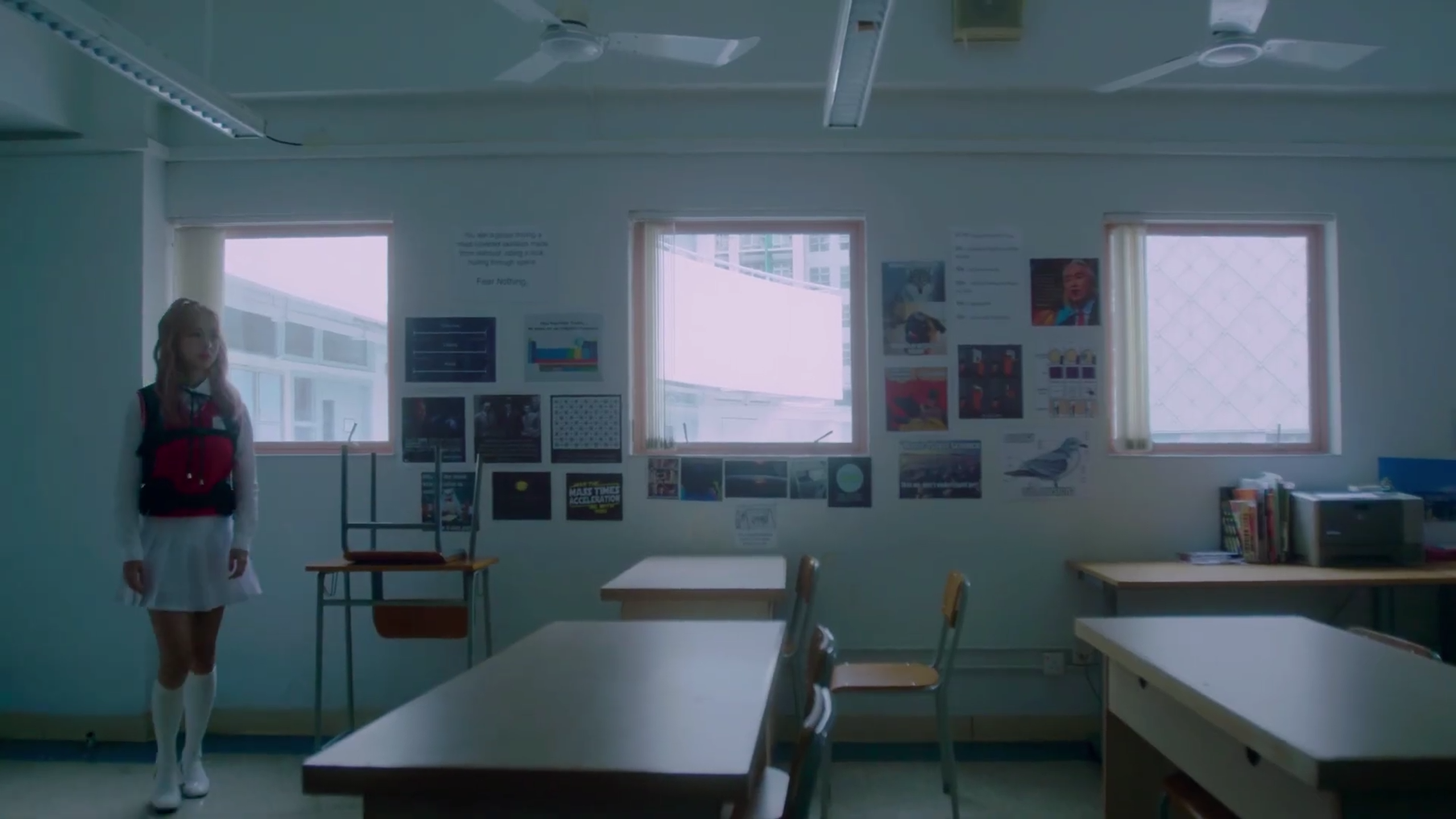 Vivi standing in an empty classroom.